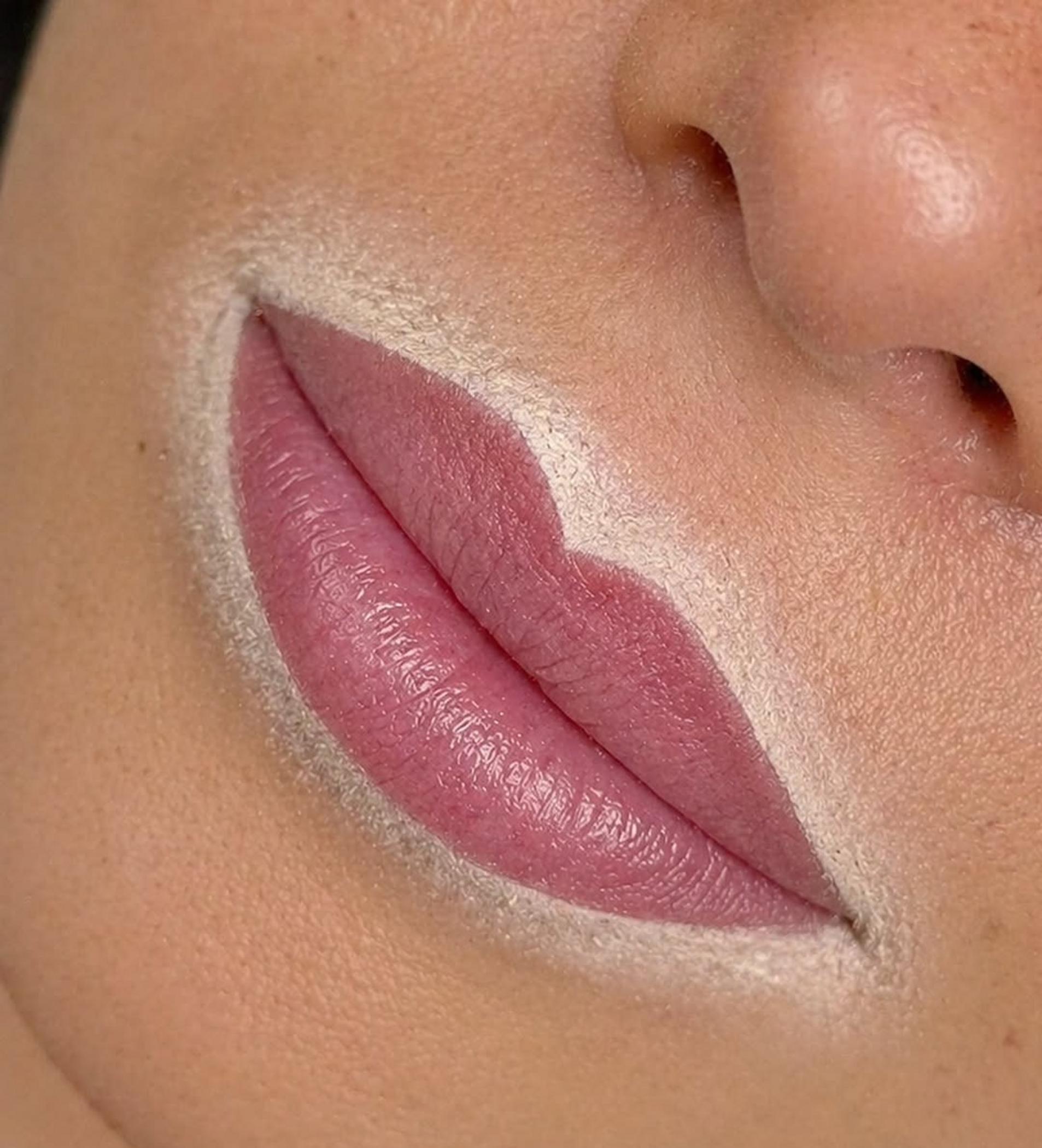 technician applying lip tattoo pigment
